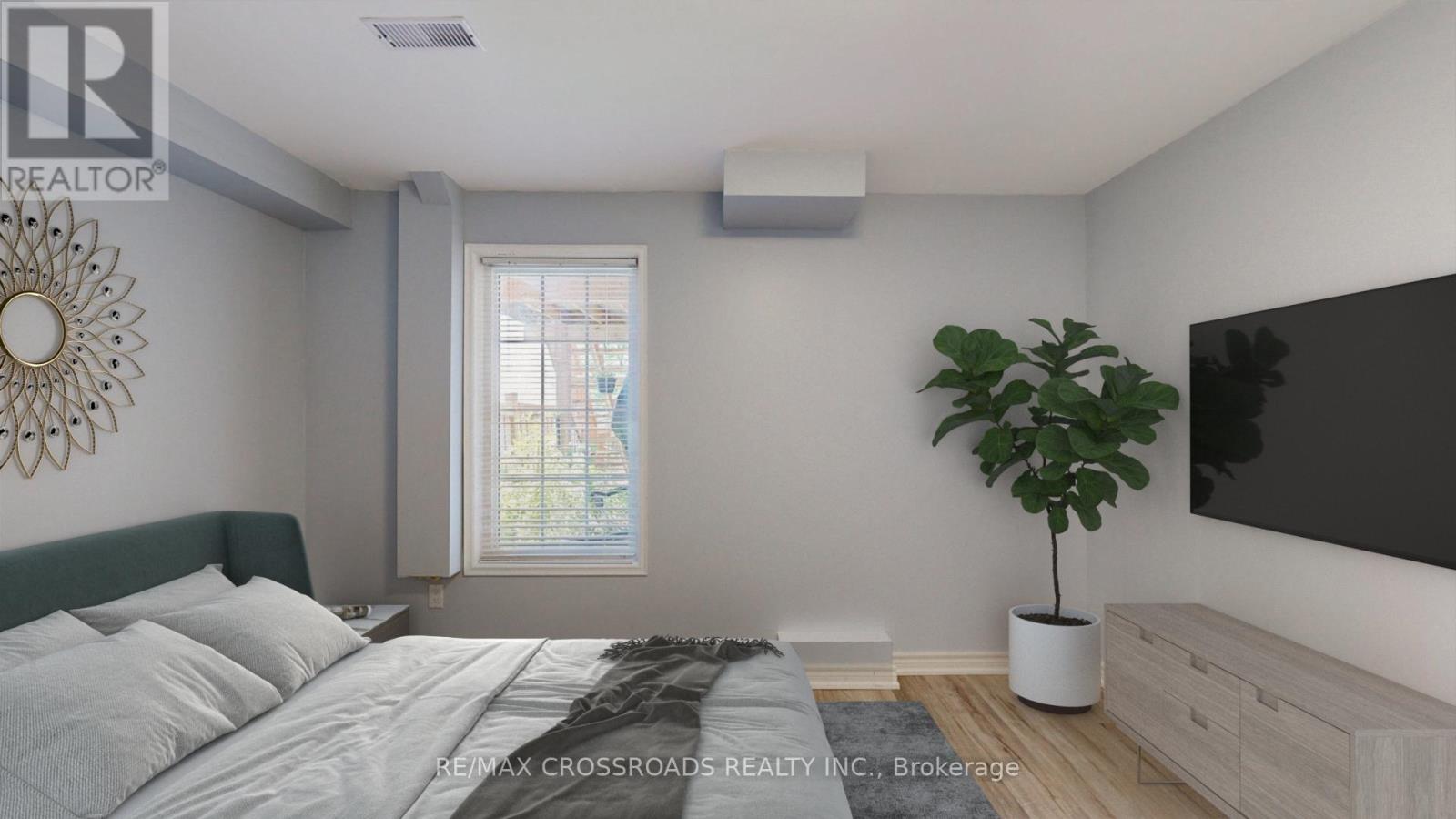 A bedroom with a bed, a plant, and a television.