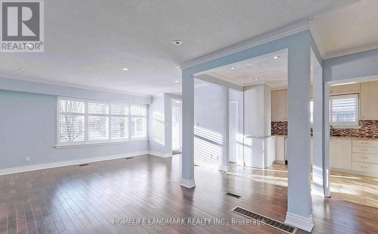 A spacious room with wooden floors and white walls.