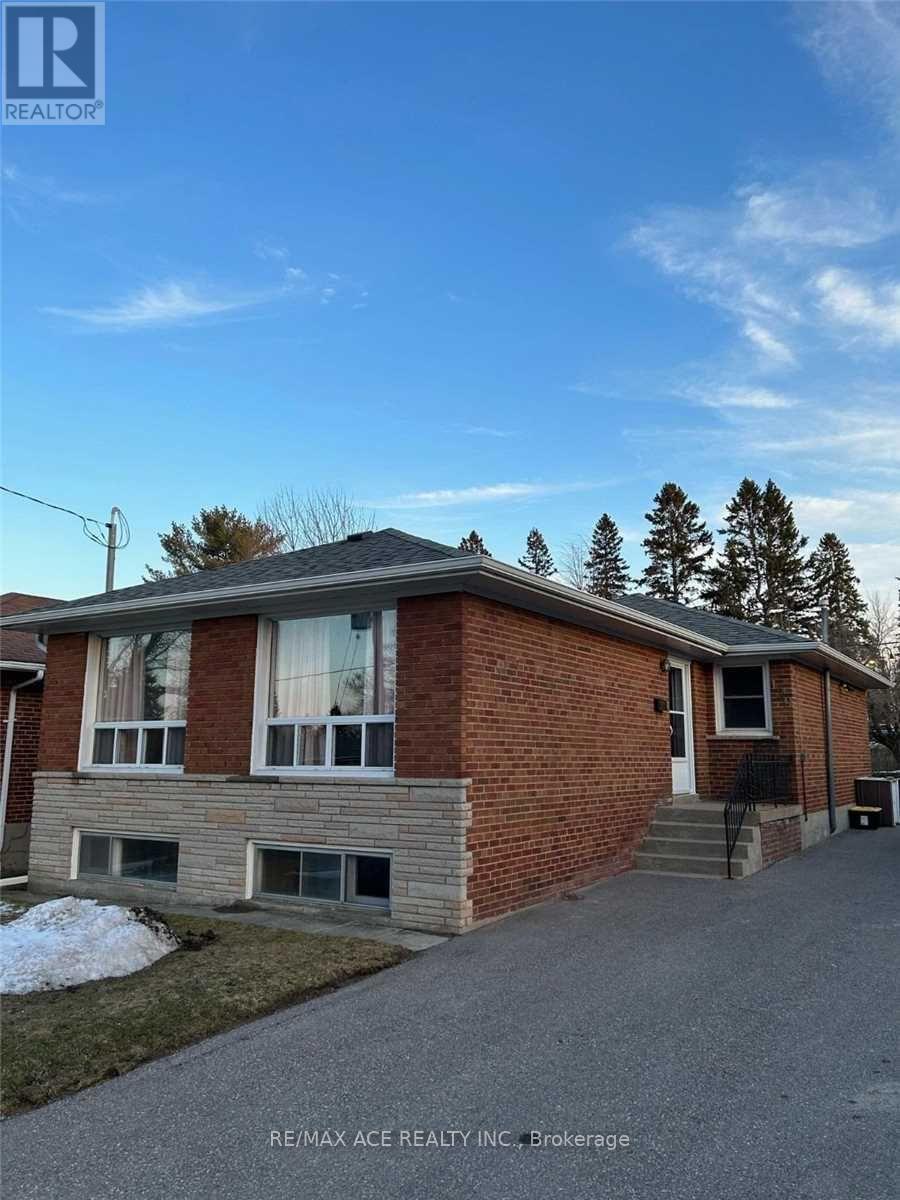 A house with a brick facade and a grey roof is shown.