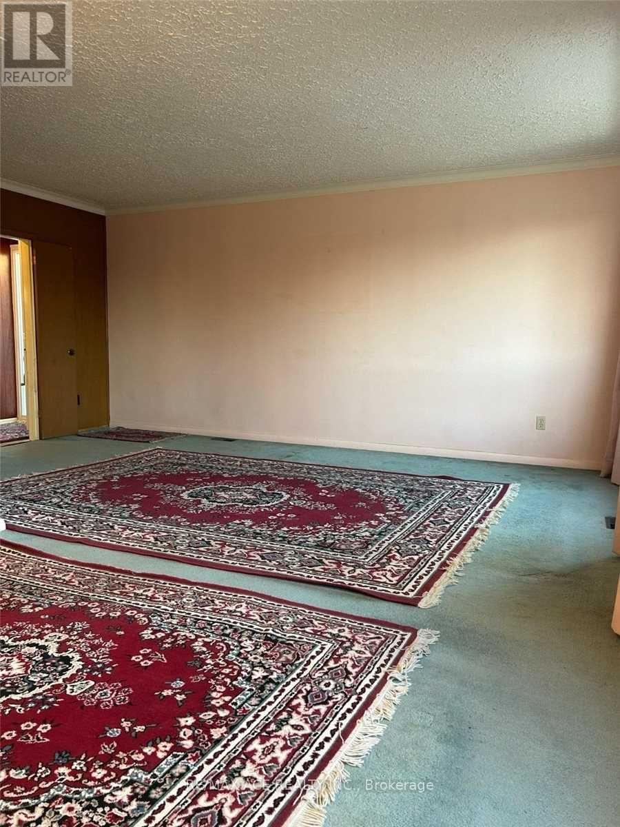 A room with two red rugs and a white ceiling.
