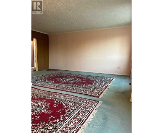 A room with two red rugs and a white ceiling.