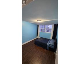 A bedroom with a bed and a window.