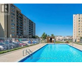 A swimming pool in a residential area with apartment buildings in the background.