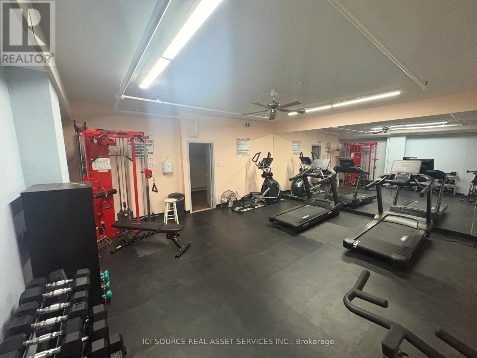 A gym with treadmills, weights, and exercise equipment.