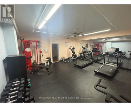 A gym with treadmills, weights, and exercise equipment.