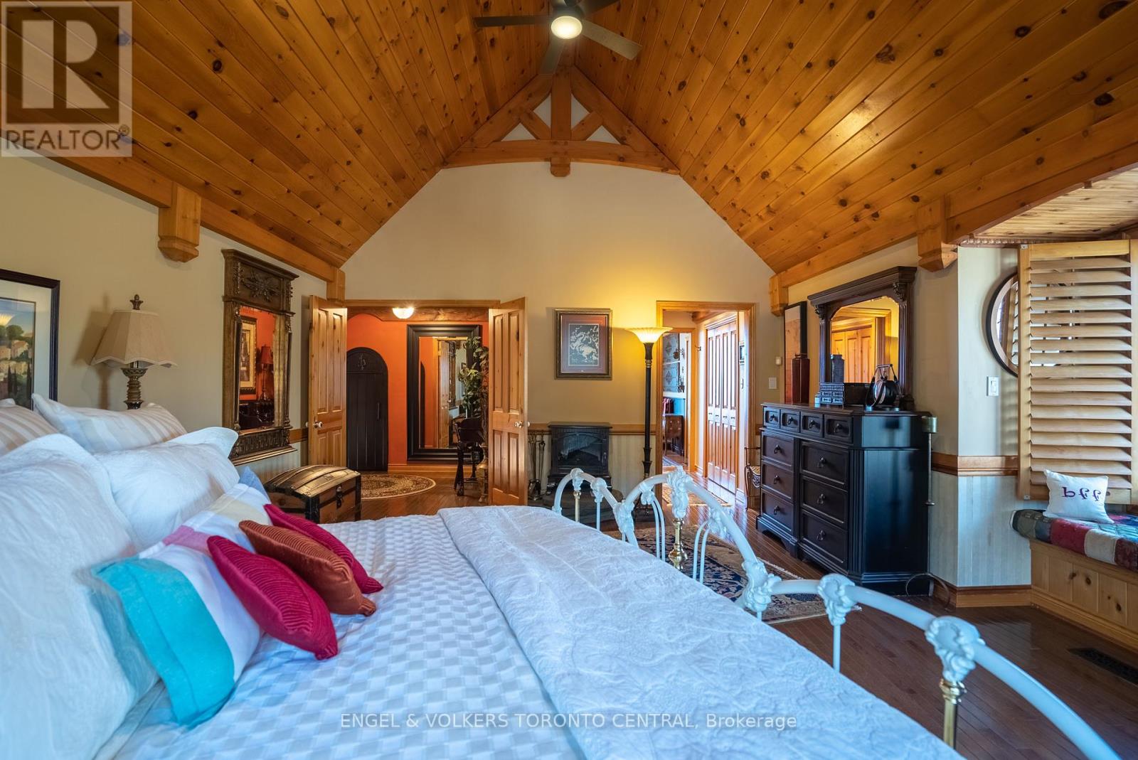A bedroom with a large bed and wooden walls.