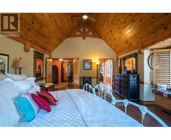 A bedroom with a large bed and wooden walls.