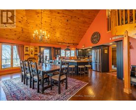 A large dining room with a wooden table and chairs.