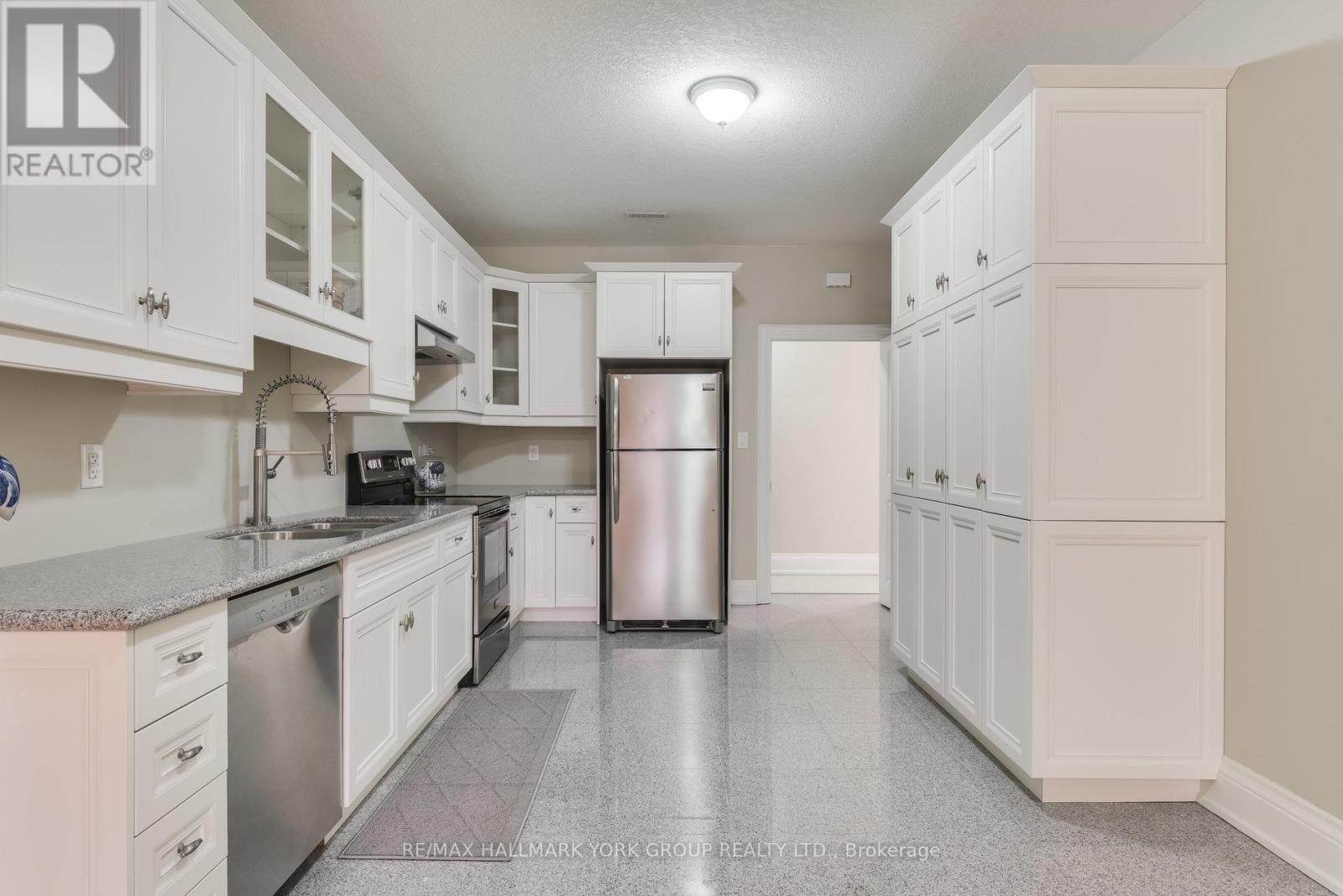 A kitchen with white cabinets and a refrigerator.