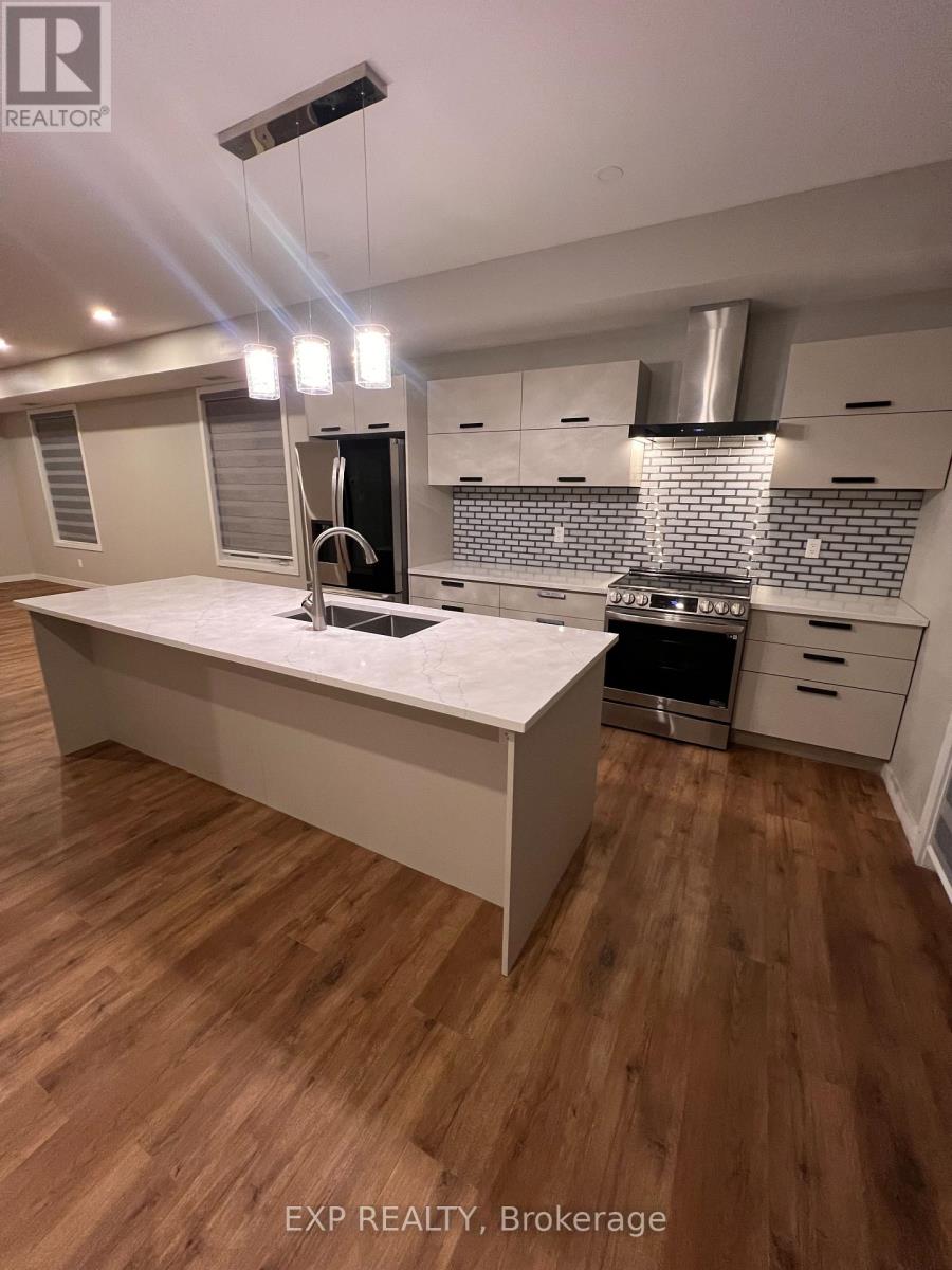 A modern kitchen with wooden floors and white cabinetry.