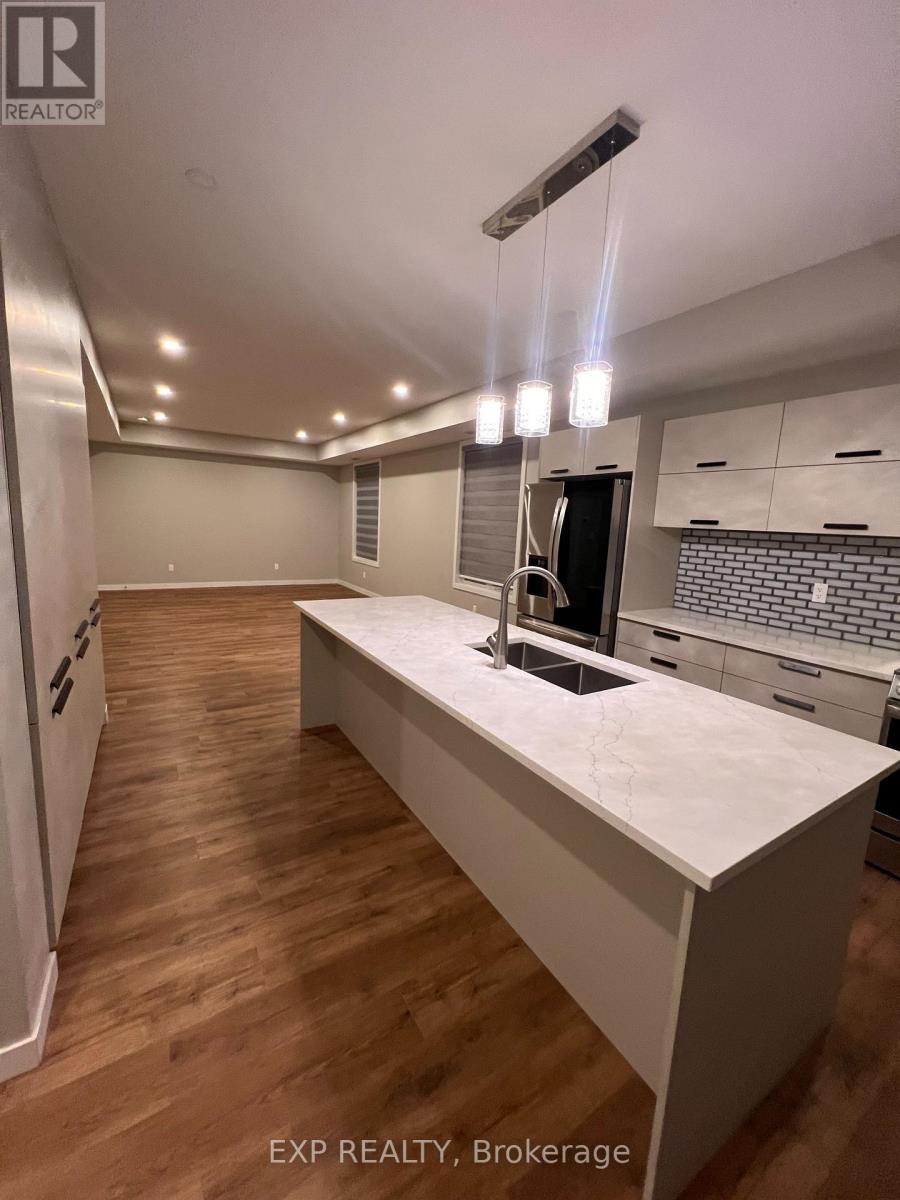 A kitchen with a white countertop and wooden flooring.