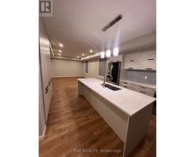 A kitchen with a white countertop and wooden flooring.