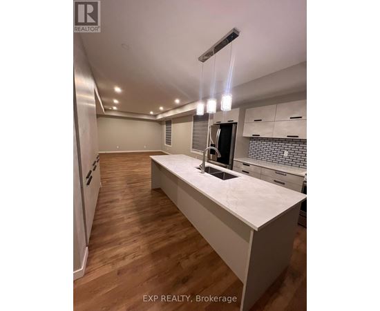 A kitchen with a white countertop and wooden flooring.