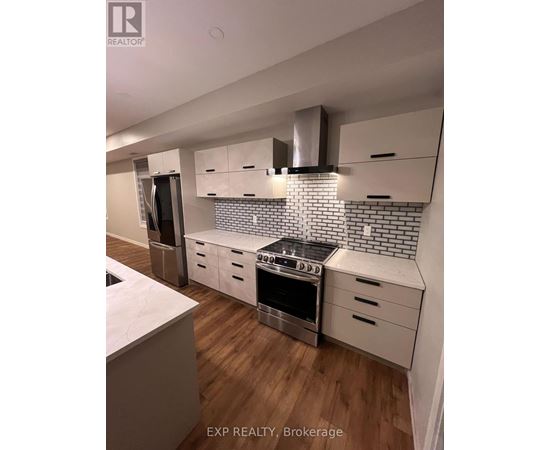 A kitchen with a stove top oven and a refrigerator.