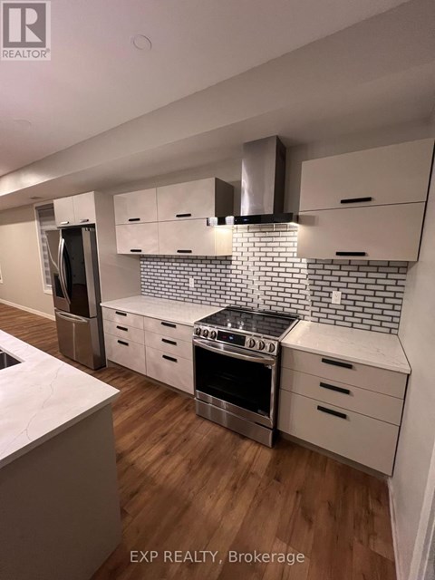 A kitchen with a stove top oven and a refrigerator.