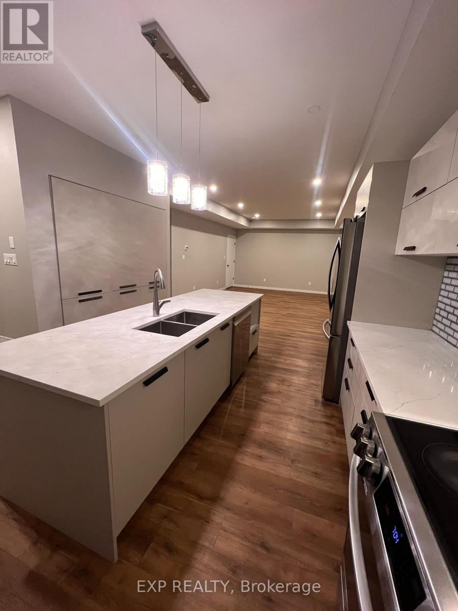 A modern kitchen with white cabinets and a wooden floor.