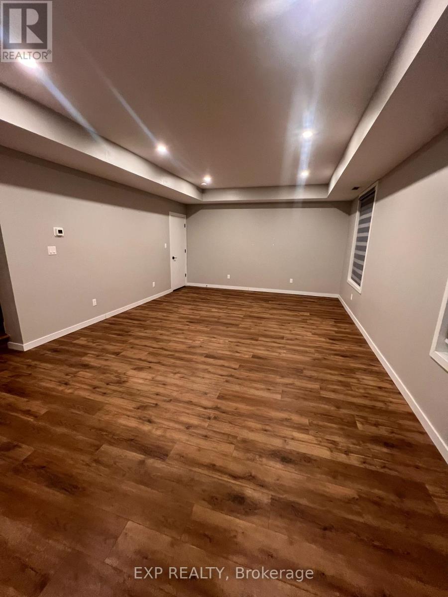 A room with wooden flooring and white walls.