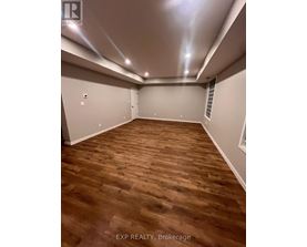 A room with wooden flooring and white walls.