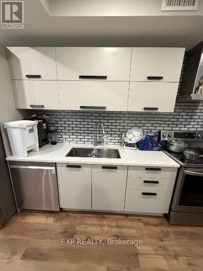 A kitchen with white cabinets and a brick backsplash.