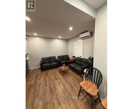 A living room with a black couch set and a wooden coffee table.