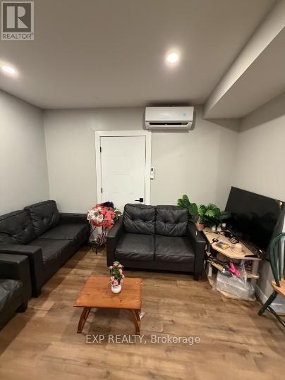A living room with a black couch and a wooden coffee table.
