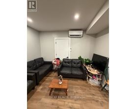 A living room with a black couch and a wooden coffee table.