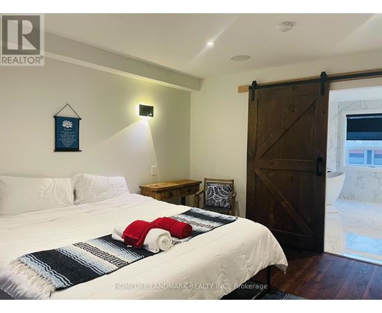 A bedroom with a bed, nightstand, and a door.