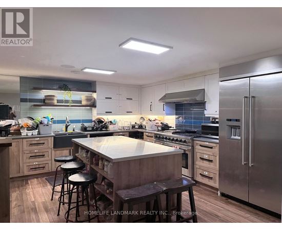 A modern kitchen with stainless steel appliances and wooden cabinets.