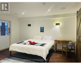 A bedroom with a bed, desk, chair, and a window.