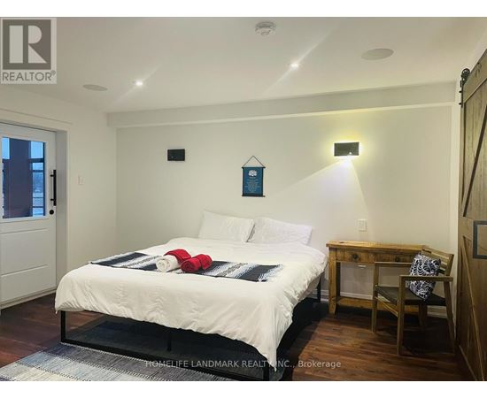 A bedroom with a bed, desk, chair, and a window.