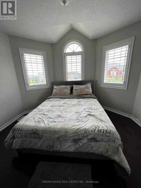A bedroom with a bed in the center and two windows on the wall.