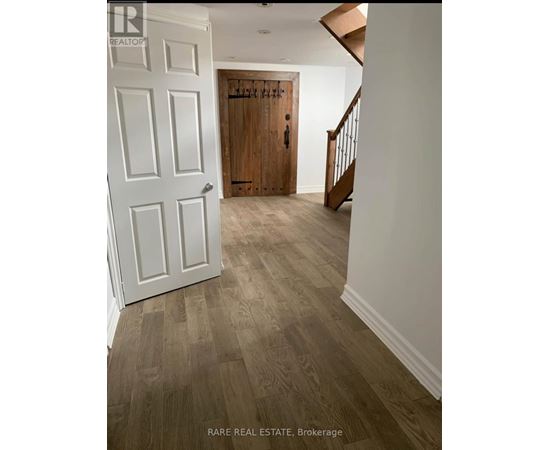 A hallway with a white door and a wooden door at the end.