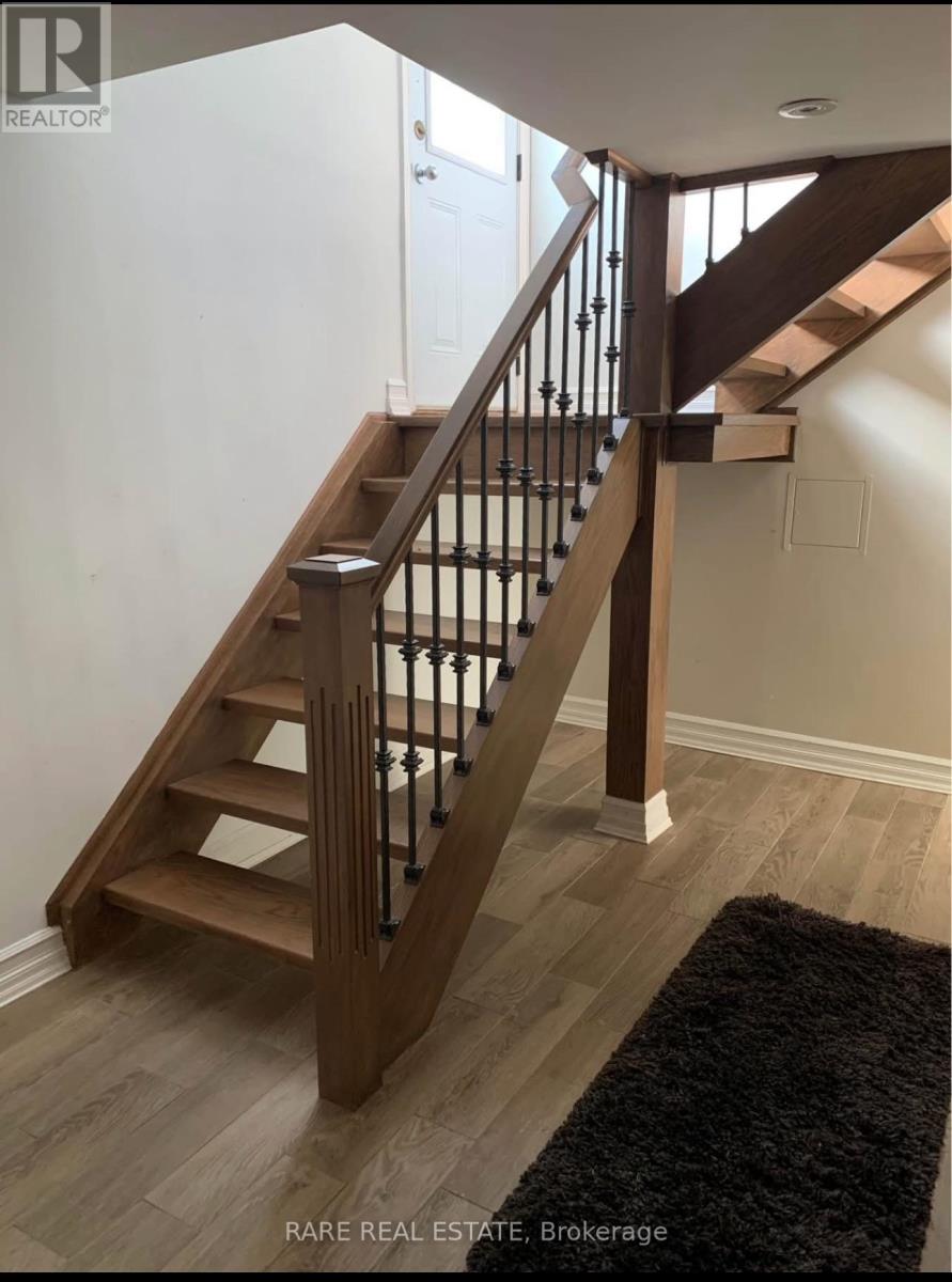 A wooden staircase with a black metal railing.