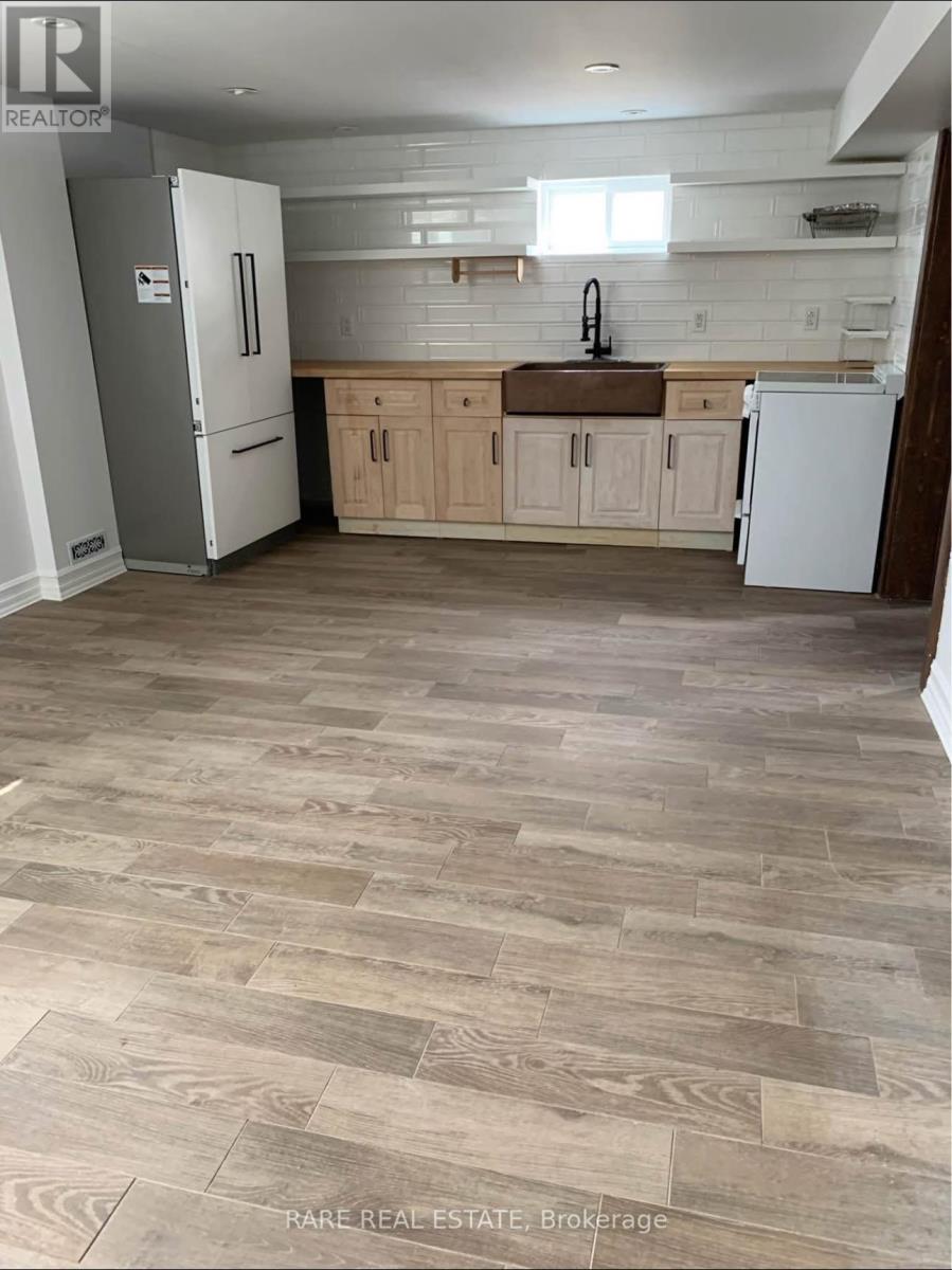 A kitchen with a white fridge and wooden cabinets.