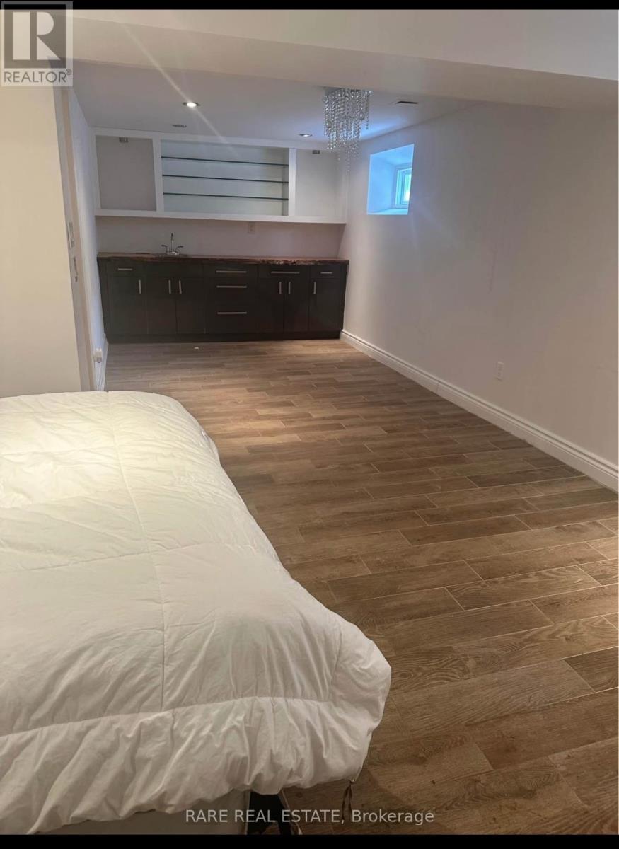 A bedroom with a bed and wooden flooring.