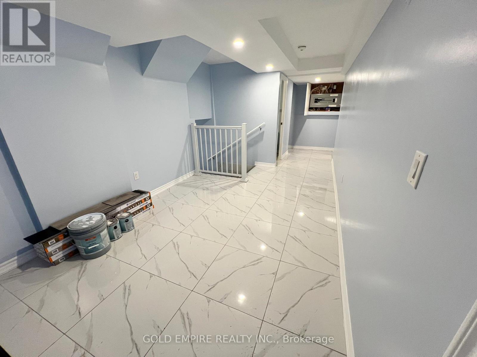 A room with a white marble floor and blue walls.