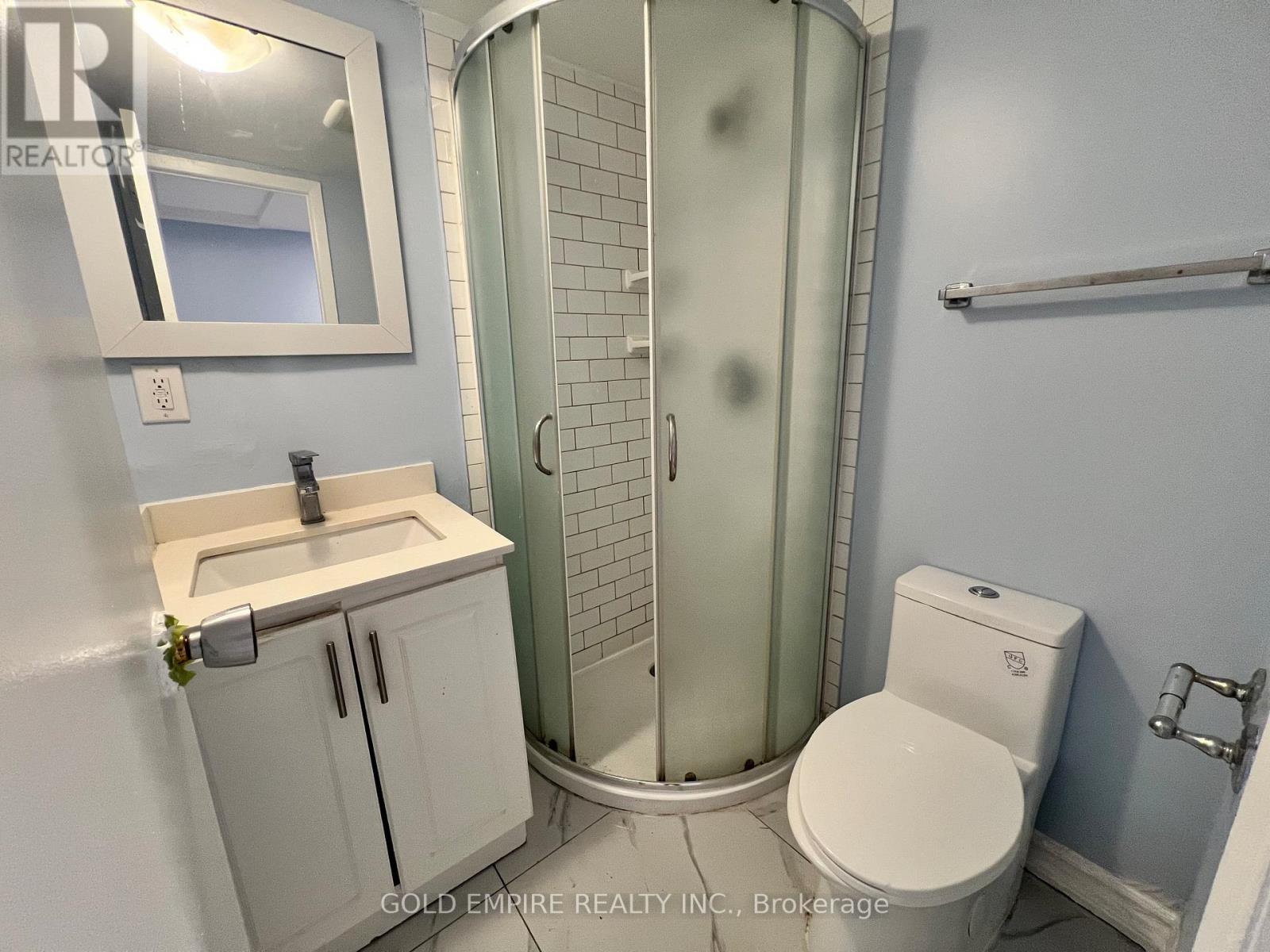 A bathroom with a toilet, sink, and shower.