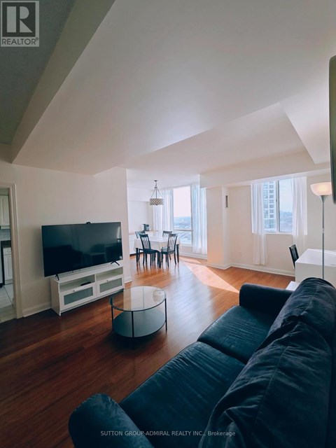 A living room with a black couch and a television.