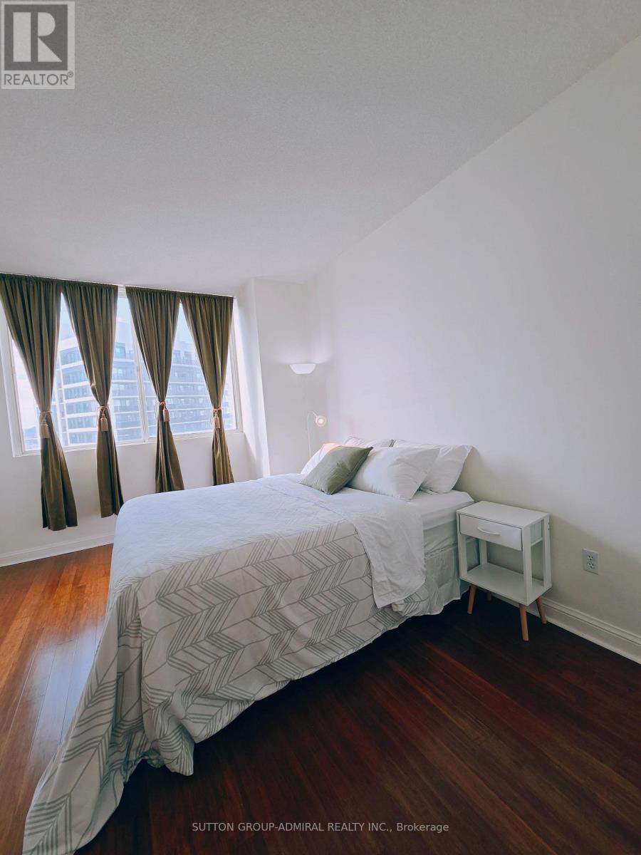 A bedroom with a large bed and a small nightstand.