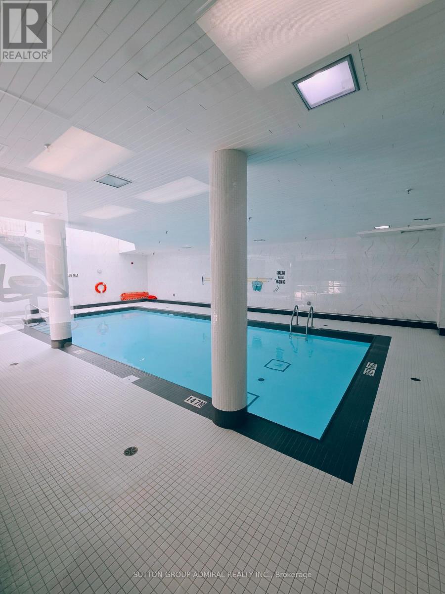 A large indoor swimming pool with a black edge and a white ceiling.