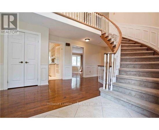 A spacious home interior with a staircase leading to the upper floor.