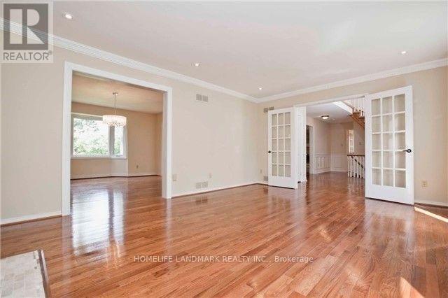 A spacious room with wooden floors and white walls.