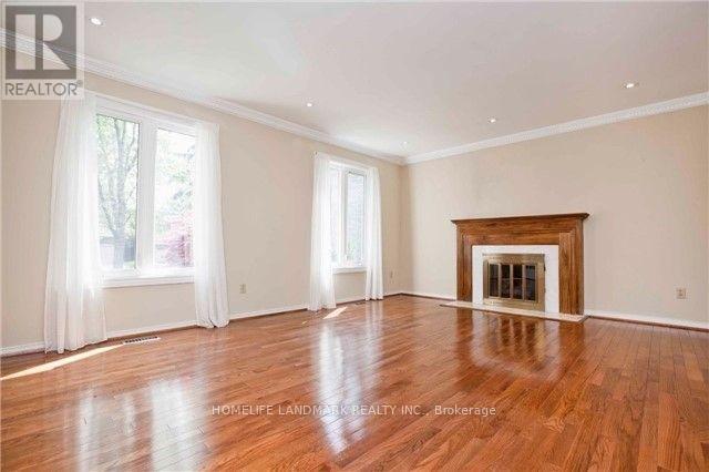 A spacious room with a fireplace and hardwood floors.