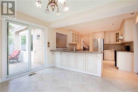 A spacious kitchen with white cabinets and a refrigerator.