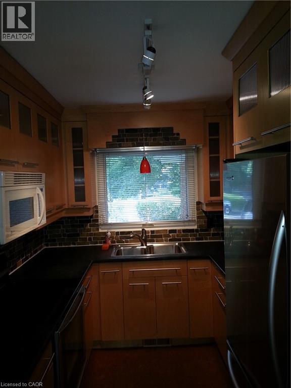 A kitchen with wooden cabinets and black countertops.