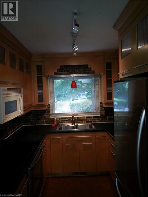 A kitchen with wooden cabinets and black countertops.
