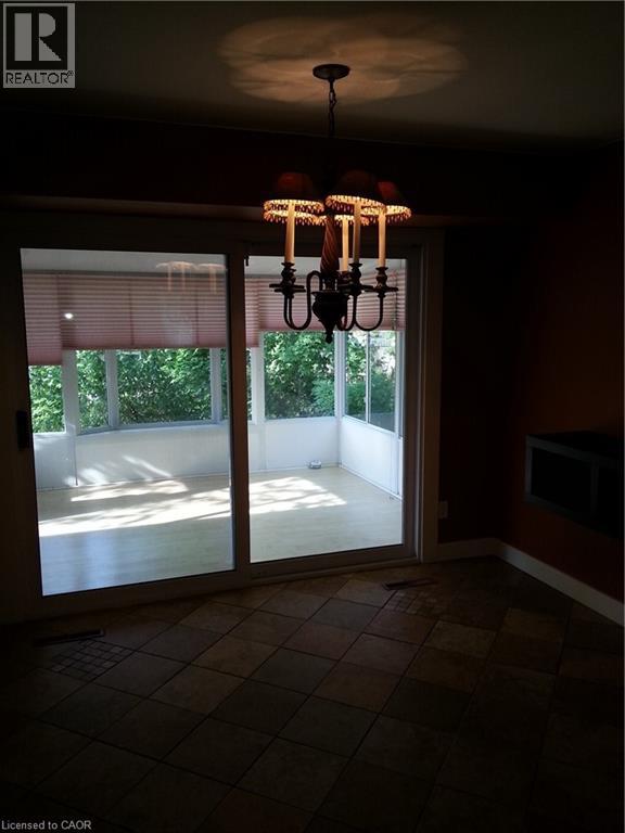 A chandelier hangs in a room with a sliding glass door.