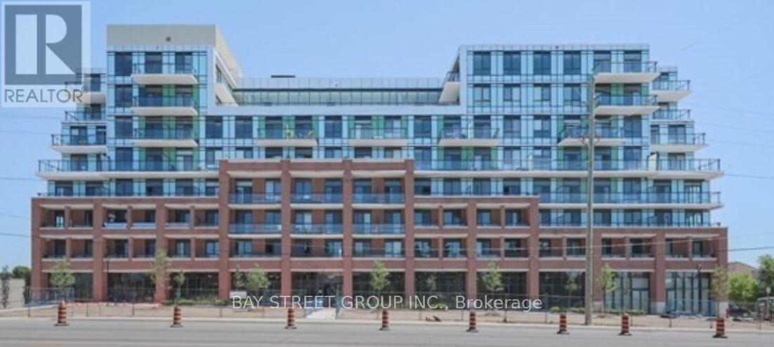 A large building with a glass facade on top and a brick facade on the bottom.