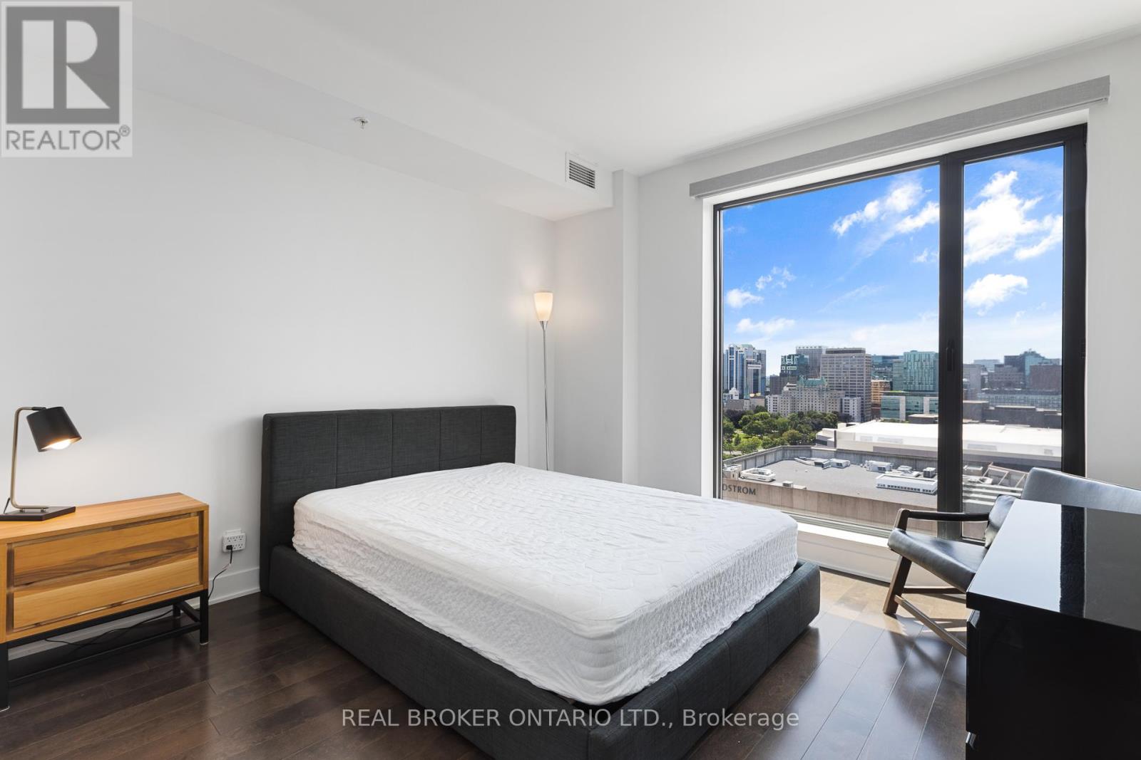 A bedroom with a large bed and a view of the city.