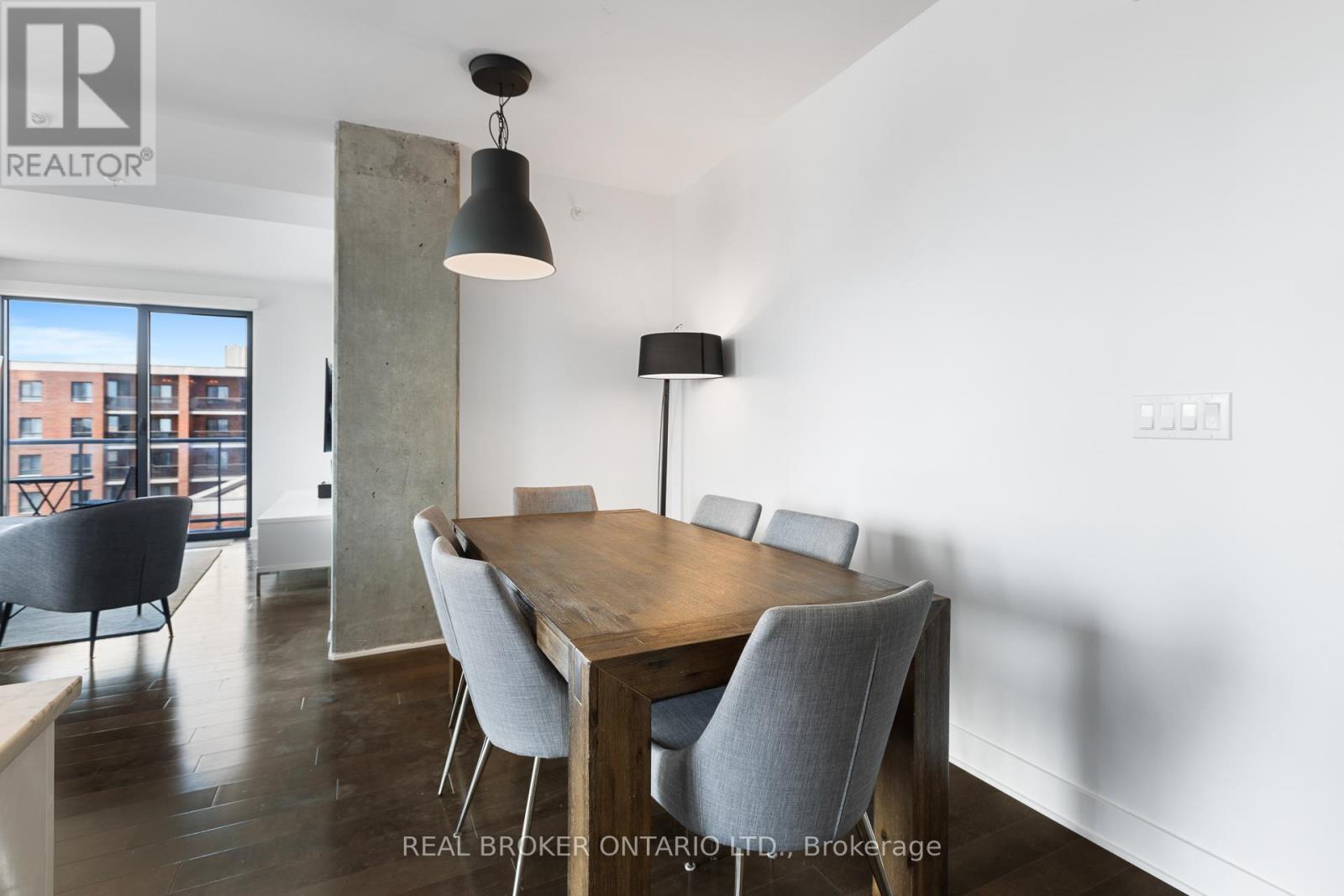 A dining room with a wooden table and grey chairs.